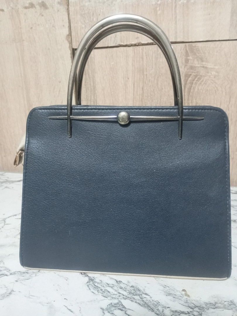 Vintage Two-Tone Top Handle Handbag (Category: Luxury Bags & Wallets) located in Pasay City. Submitted by royal_loveshop (Listing ID 1461456963, Image 3). Description: - Classic dark blue and beige handbag - Retro-inspired design - Secure metal clasp closure - Convenient front pocket - Interior zippered compartment - Shiny metal handles - Approximate dimensions: 12 inches wide x 8 inches tall.