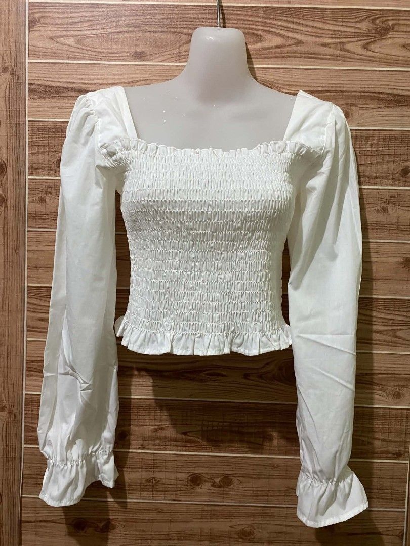 Wego White Smocked Puff-Sleeve Blouse (Category: Longsleeves) located in Binan City. Submitted by katespanie (Listing ID 1461341772, Image 1). Description: Good pre-loved condition. Maayos pa overall and walang obvious na major stains, holes, or damages. May konting wrinkles/creases lang from storage or handling, pero okay pa yung smocked details and sleeves. Clean and presentable pa siya. 📍 Location: LAGUNA 🚚 Lalamove delivery available. 💸 Sh