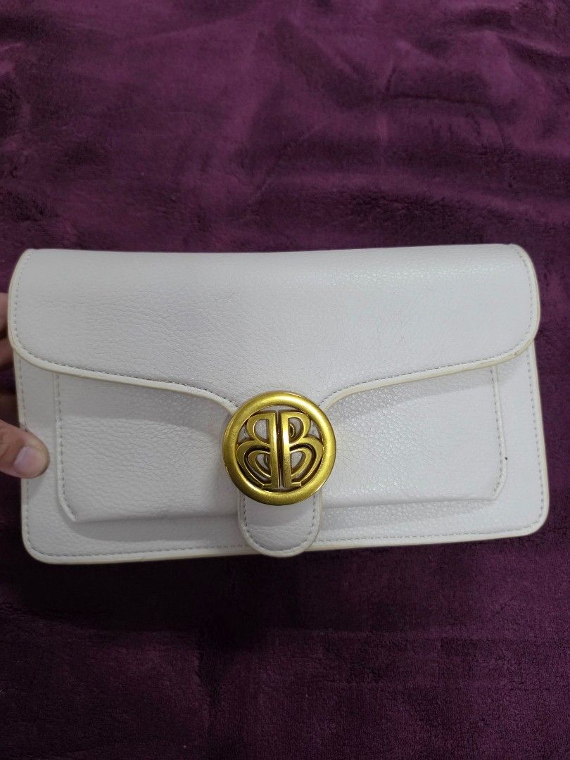 White Leather Clutch Bag with Gold Hardware (Category: Clutches) located in Manila. Submitted by f3v1nadump (Listing ID 1461377000, Image 1). Description: - Chic white leather clutch bag - Secure gold-tone clasp closure - Includes a detachable strap for versatility - Features an interior zippered pocket for essentials - Classic and clean design, ideal for evening wear or special occasions.
