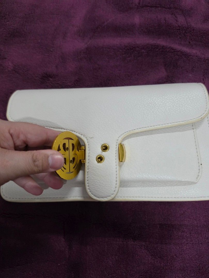 White Leather Clutch Bag with Gold Hardware (Category: Clutches) located in Manila. Submitted by f3v1nadump (Listing ID 1461377000, Image 2). Description: - Chic white leather clutch bag - Secure gold-tone clasp closure - Includes a detachable strap for versatility - Features an interior zippered pocket for essentials - Classic and clean design, ideal for evening wear or special occasions.