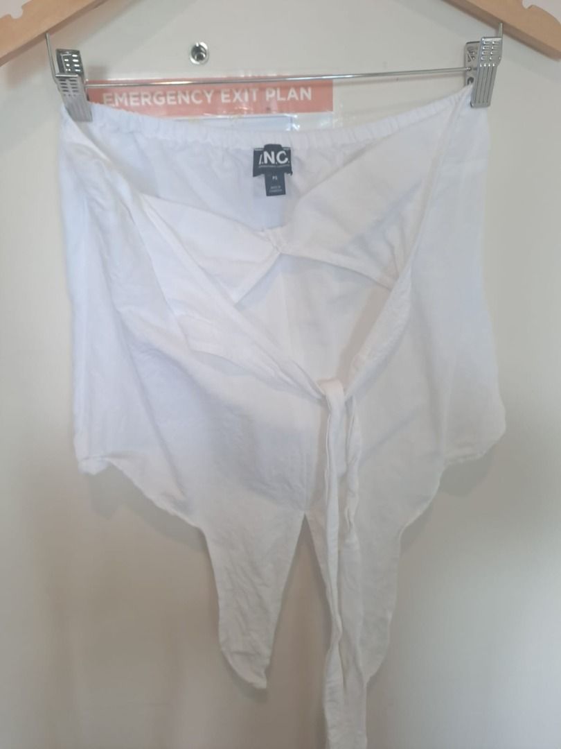 white linen halter (Category: Sleeveless) located in Mandaluyong City. Submitted by epicowl-c93c (Listing ID 1461427687, Image 3). Description: The image shows a white cotton linen halter top styled with a drawstring or elastic back closure and a tied neck finish. This lightweight, open-back silhouette features a loose, pointed asymmetrical front hemline making it a great piece for beach vacations or summer street styling..
