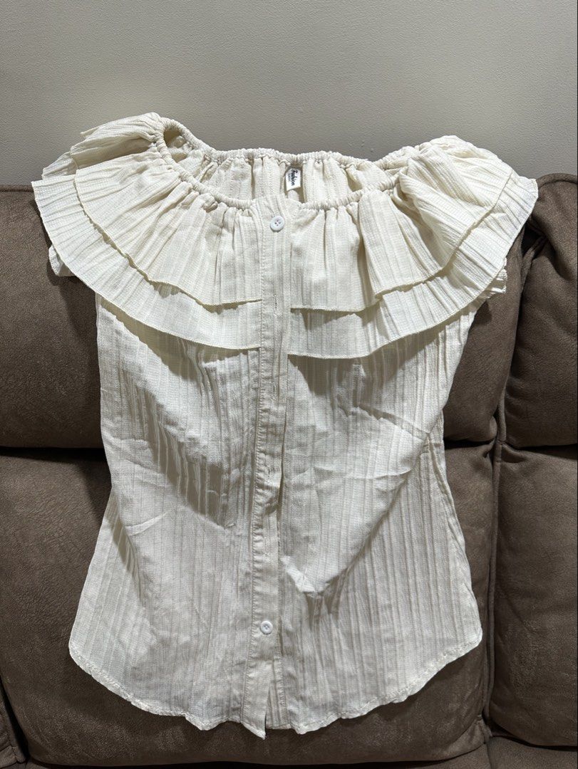 White Off-Shoulder Ruffle Blouse (Category: Blouses) located in Manila. Submitted by nasalgahan76152 (Listing ID 1461465994, Image 1). Description: - Cute white off-shoulder blouse - Features ruffles across chest and neckline - Button-up front - Textured fabric - Versatile for casual or dressy looks - Easy to style.