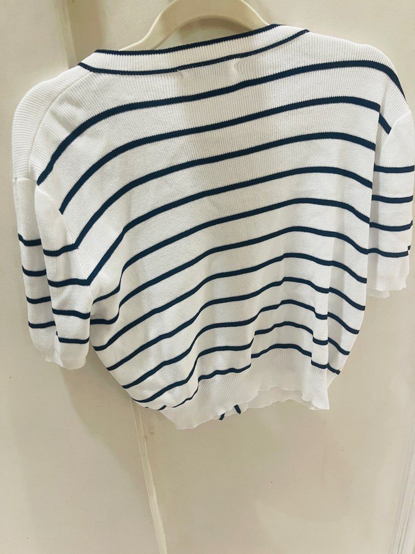 White Striped Knit Top with Gold Buttons (Category: Shirts) located in Quezon City. Submitted by prelovedluxe_ (Listing ID 1461364232, Image 3). Description: Classic and effortlessly polished white striped knit top featuring elegant contrast piping and decorative gold-tone buttons. The timeless nautical-inspired stripe pattern is complemented by a refined round neckline and button-front detail, creating a sophisticated, feminine look. Made from a