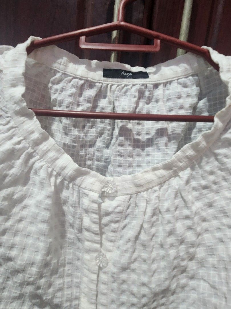 White Textured Puff Sleeve Top (Category: Blouses) located in Muntinlupa City. Submitted by yanyan1888 (Listing ID 1461372543, Image 2). Description: - Chic white top with a unique textured, crinkled fabric. - Features stylish puff sleeves for a feminine touch. - Elegant round neckline adorned with small button details. - Tag indicates size small, ideal for a petite fit. - Versatile piece, perfect for elevating your everyday casual wear..