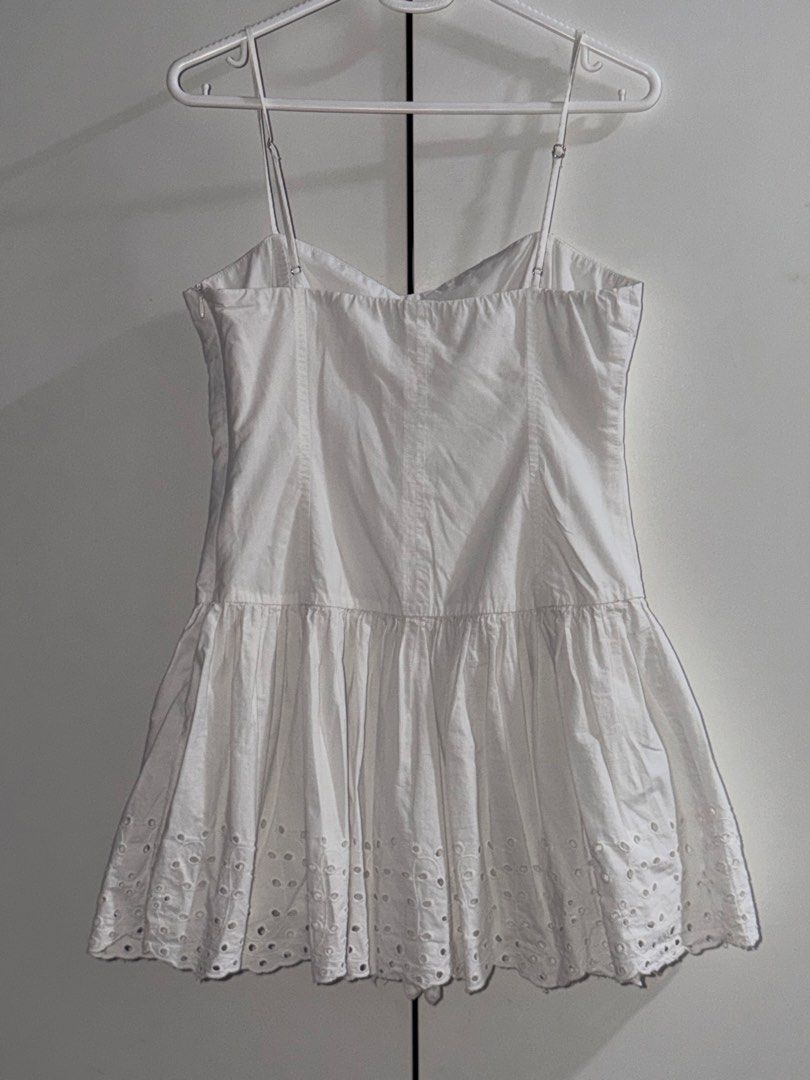 Zara Dress (Category: Dresses) located in Manila. Submitted by closetbykiks (Listing ID 1461474588, Image 3). Description: Brand: ZARA Size: Small Colors Included: White Style: Sleeveless drop-waist mini dress with a sweetheart/corset-style neckline, adjustable thin straps, side zipper closure, and an eyelet embroidered hem Fabric: Crisp 100% cotton woven fabric Condition: Good pre-owned condition (features a faint, minor mark near the front fold