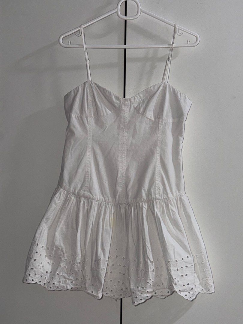 Zara Dress (Category: Dresses) located in Manila. Submitted by closetbykiks (Listing ID 1461474588, Image 2). Description: Brand: ZARA Size: Small Colors Included: White Style: Sleeveless drop-waist mini dress with a sweetheart/corset-style neckline, adjustable thin straps, side zipper closure, and an eyelet embroidered hem Fabric: Crisp 100% cotton woven fabric Condition: Good pre-owned condition (features a faint, minor mark near the front fold