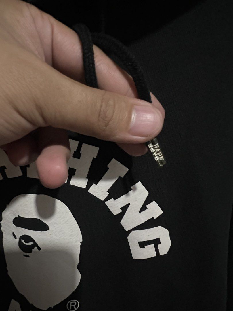 A Bathing Ape BAPE Hoodie Black Size L (Category: Hoodies) located in Pili. Submitted by r.chives (Listing ID 1461628838, Image 2). Description: - Black BAPE hoodie - Features classic ape head logo graphic on the front - Drawstring hood with metal aglets - Size: Large (L) - Ideal for casual wear.