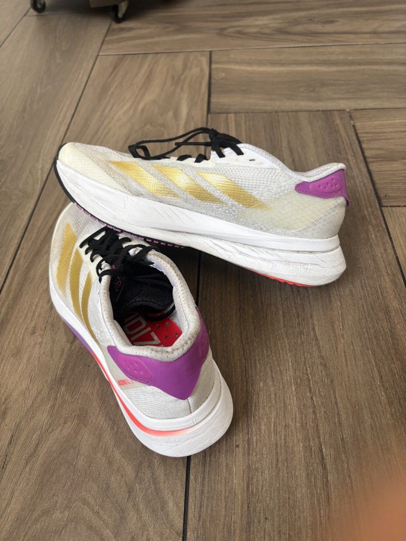Adidas Adizero SL2 (Category: Sneakers) located in Paranaque City. Submitted by gabbyrela (Listing ID 1461568276, Image 2). Description: - Adidas SL2 - Color: White with gold stripes and purple accents - Size: 6 US Men/7.5 US Women .