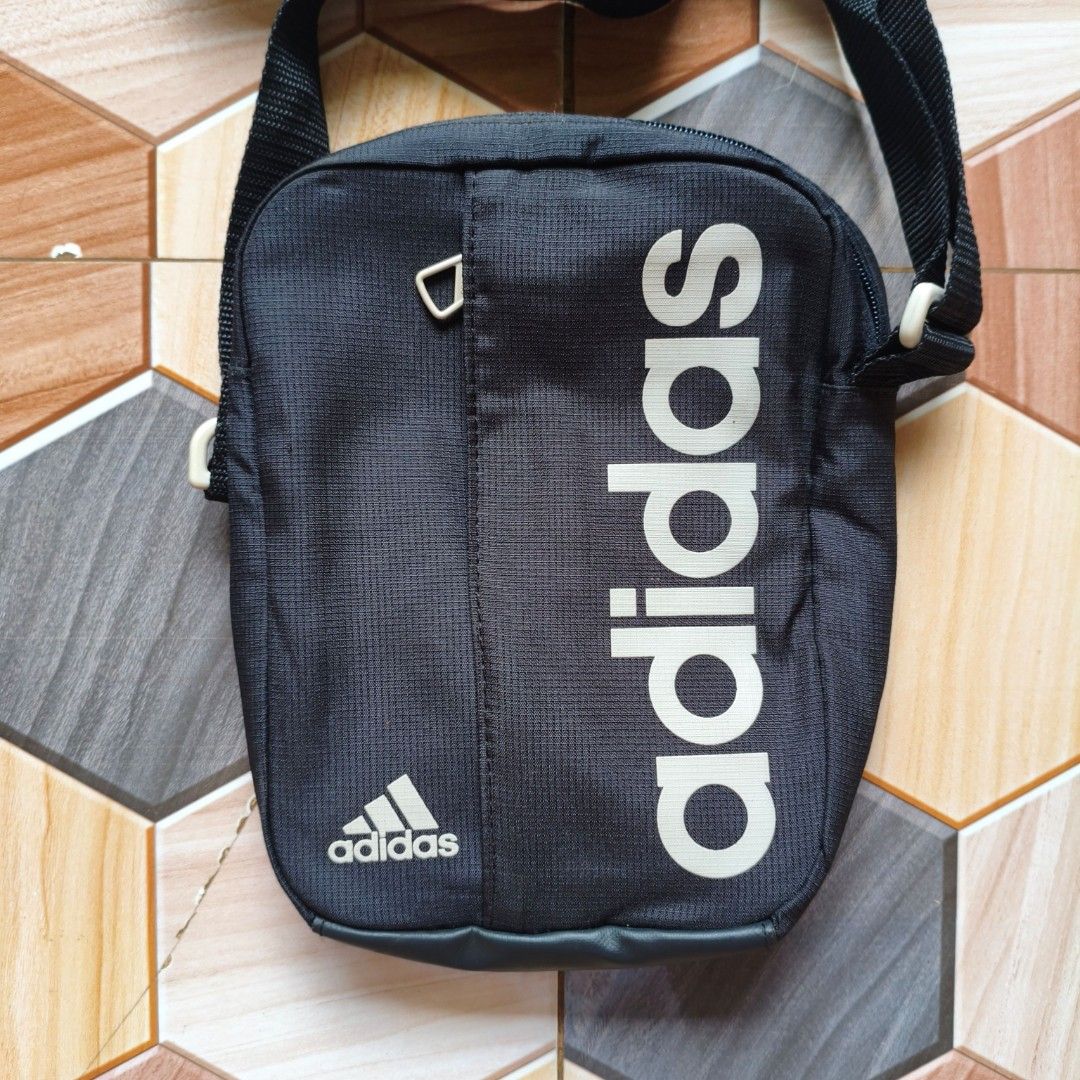 Adidas Black Crossbody Sling Bag (Category: Sling Bags) located in Manila. Submitted by caps08 (Listing ID 1461594821, Image 2). Description: - Black Adidas sling bag - Features Adidas logo on front and side - Adjustable strap for comfortable wear - Zippered pocket for secure storage - Ideal for carrying daily essentials - Great for everyday use.