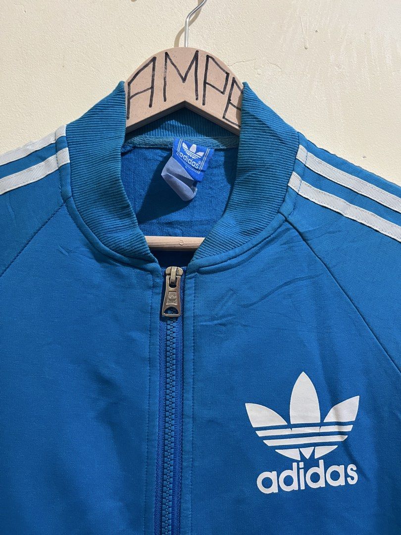 Adidas Blue Track Jacket with Trefoil Logo (Category: Coats, Jackets and Outerwear) located in Manila. Submitted by juspheroca82034 (Listing ID 1461683483, Image 3). Description: - Classic blue Adidas track jacket - Iconic trefoil logo on back and chest - White stripes on sleeves - Zip-up front with pockets - Ribbed cuffs and hem - Ideal for casual wear or sports -for kids 8-10 yrs old.