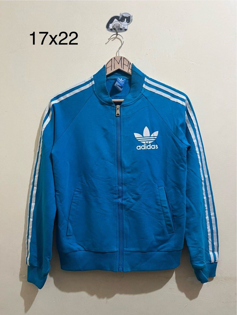 Adidas Blue Track Jacket with Trefoil Logo (Category: Coats, Jackets and Outerwear) located in Manila. Submitted by juspheroca82034 (Listing ID 1461683483, Image 1). Description: - Classic blue Adidas track jacket - Iconic trefoil logo on back and chest - White stripes on sleeves - Zip-up front with pockets - Ribbed cuffs and hem - Ideal for casual wear or sports -for kids 8-10 yrs old.
