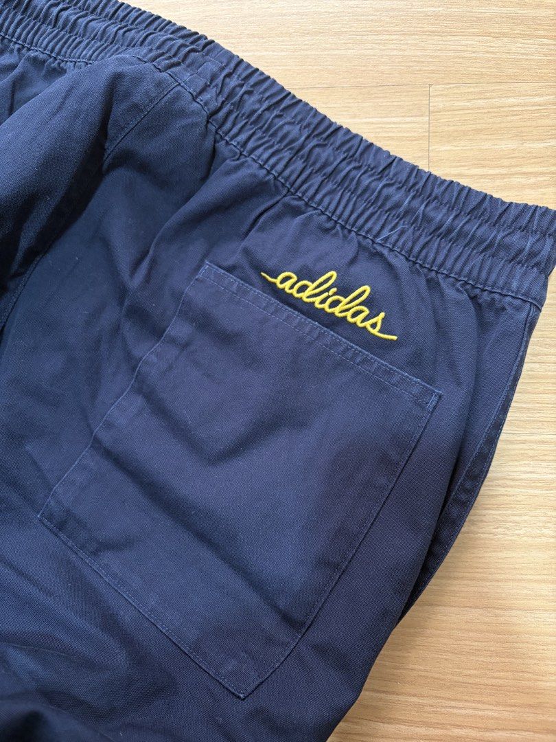 Adidas Navy Blue Track Pants with Yellow Logo (Category: Joggers) located in Makati City. Submitted by citysunset (Listing ID 1461644103, Image 3). Description: - Navy blue Adidas track pants - Length: 38.5 inches - Waist: 34 inches (stretchable) - Classic yellow Adidas trefoil logo on left thigh - Comfortable elastic waistband - Two yellow stripes down the sides - Back pocket with embroidered Adidas script logo - Ideal for casual wear or sports 