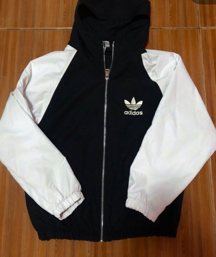 Adidas Windbreaker Jacket (Category: Coats, Jackets and Outerwear) located in Antipolo. Submitted by strawberricae (Listing ID 1461724082, Image 2). Description: - Classic Adidas windbreaker jacket - Color: Black body with white sleeves and hood - Full zip closure - Elasticated cuffs and hem - Size: XL - Ideal for casual wear or light workouts.