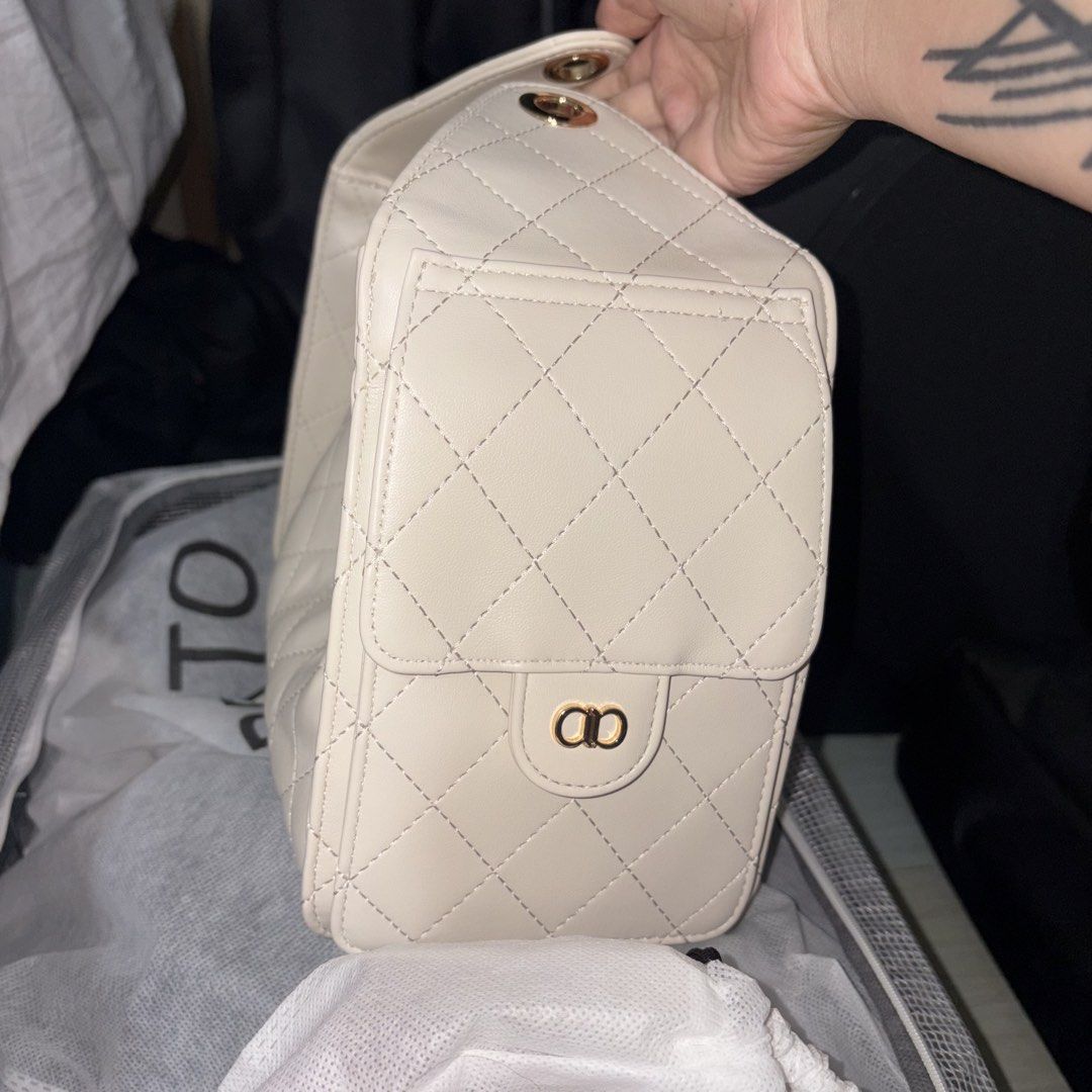 ALBERTO Quilted Chain Shoulder Bag Cream (Category: Shoulder Bags) located in Iloilo. Submitted by nana_osaki07071999 (Listing ID 1461656753, Image 2). Description: - Elegant cream quilted handbag - Stylish gold chain details - Convenient front flap pocket - Spacious main compartment - Interior lining with all-over ALBERTO logo print - Secure magnetic snap closure on front flap - Easy drawstring closure at the top - Luxurious gold hardware throug