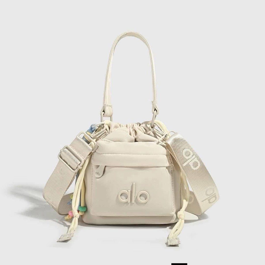Alo Yoga Bucket Bag - Multiple Colors Available (Category: Beach Bags) located in Manila. Submitted by mellnavarro_45618 (Listing ID 1461693276, Image 2). Description: - Cute bucket bag from Alo Yoga - Drawstring closure - Front pocket - Top handle - Crossbody strap included - Fun beaded tassel detail - Ideal for everyday use or gym sessions.