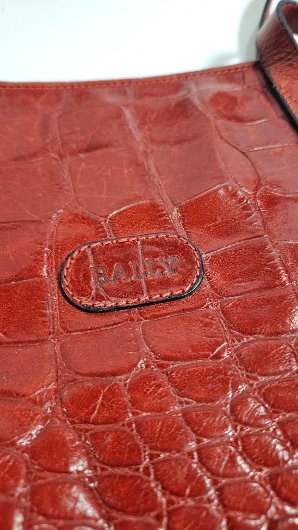Bally Red Croc Embossed Leather Tote Bag (Category: Tote Bags) located in Alfonso. Submitted by jbcamet (Listing ID 1461710582, Image 2). Description: - Genuine red leather tote bag - Elegant croc embossing - Iconic Bally logo on the front - Spacious interior for all your essentials - Internal zippered pocket with Bally zipper pull - Durable leather straps - Unique and stylish shape - Ideal for everyday wear.