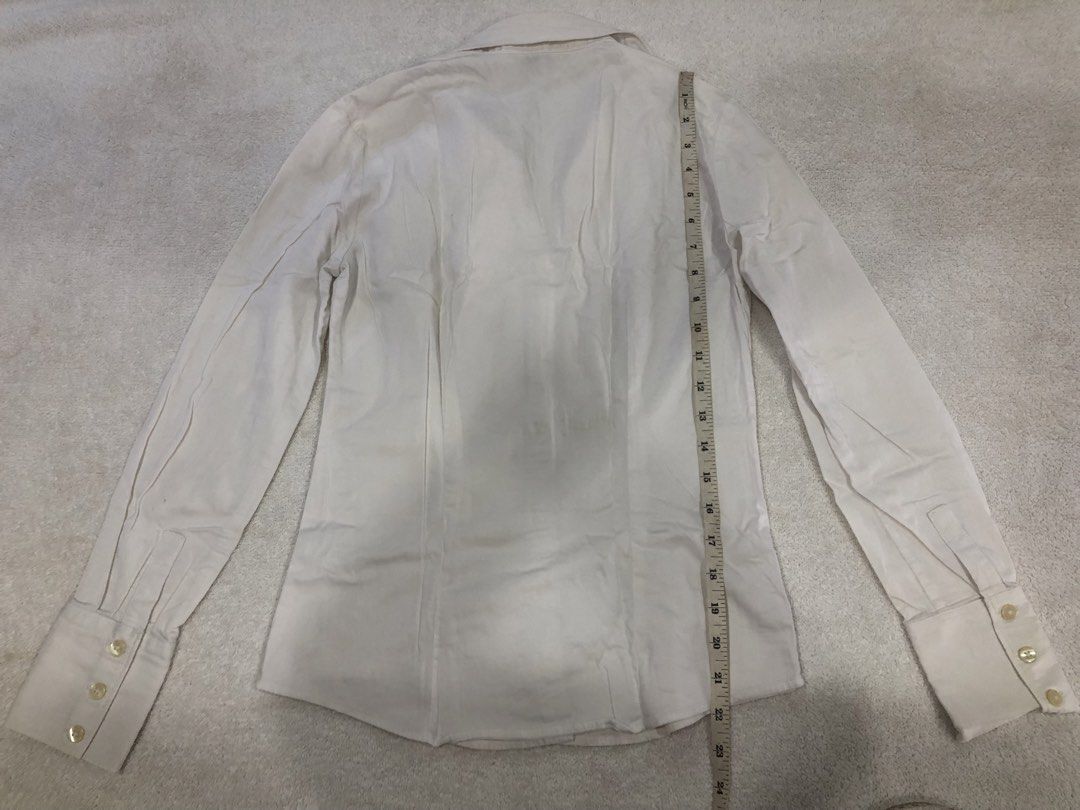 Banana Republic White Button-Up Shirt Size 0 (Category: Longsleeves) located in Manila. Submitted by janmichael26601 (Listing ID 1461617971, Image 2). Description: - Classic white button-up shirt from Banana Republic - Long sleeves with button cuffs - V-neckline with button closure - Tailored fit - Made in India - Measurements: Pit to pit approx 15 inches, length approx 23 inches.