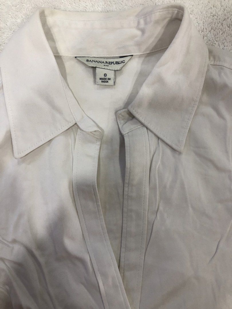 Banana Republic White Button-Up Shirt Size 0 (Category: Longsleeves) located in Manila. Submitted by janmichael26601 (Listing ID 1461617971, Image 3). Description: - Classic white button-up shirt from Banana Republic - Long sleeves with button cuffs - V-neckline with button closure - Tailored fit - Made in India - Measurements: Pit to pit approx 15 inches, length approx 23 inches.