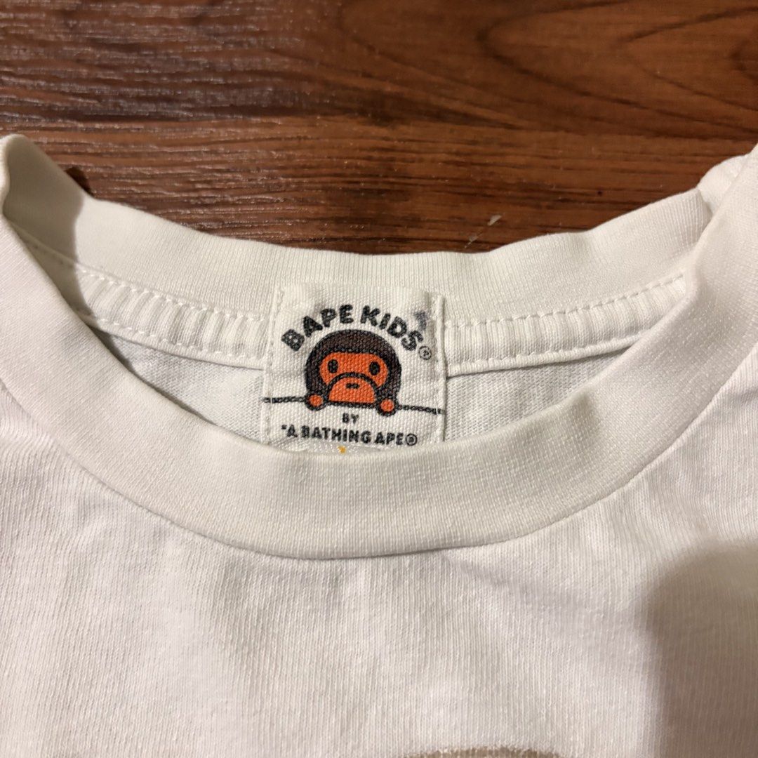 BAPE KIDS by A Bathing Ape Graphic Tee (Category: Babies & Kids Fashion) located in Cabanatuan. Submitted by house.of.thrift4 (Listing ID 1461730271, Image 3). Description: White BAPE KIDS t-shirt with iconic ape head and 'bape' logo. Authentic A Bathing Ape. Perfect for fans!.