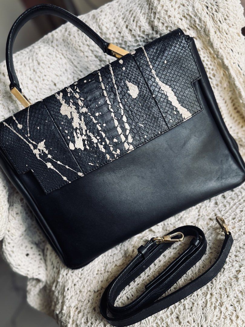 Black Leather Snake Print Handbag (Category: Luxury Bags & Wallets) located in Bacolod City. Submitted by vintage_vogue6100 (Listing ID 1461669961, Image 1). Description: - Genuine black leather handbag - Eye-catching snake print flap with unique paint splatter design - Elegant gold hardware accents - Comes with a detachable shoulder strap for versatile carrying - Spacious main compartment for all your essentials - Interior zippered pocket for se