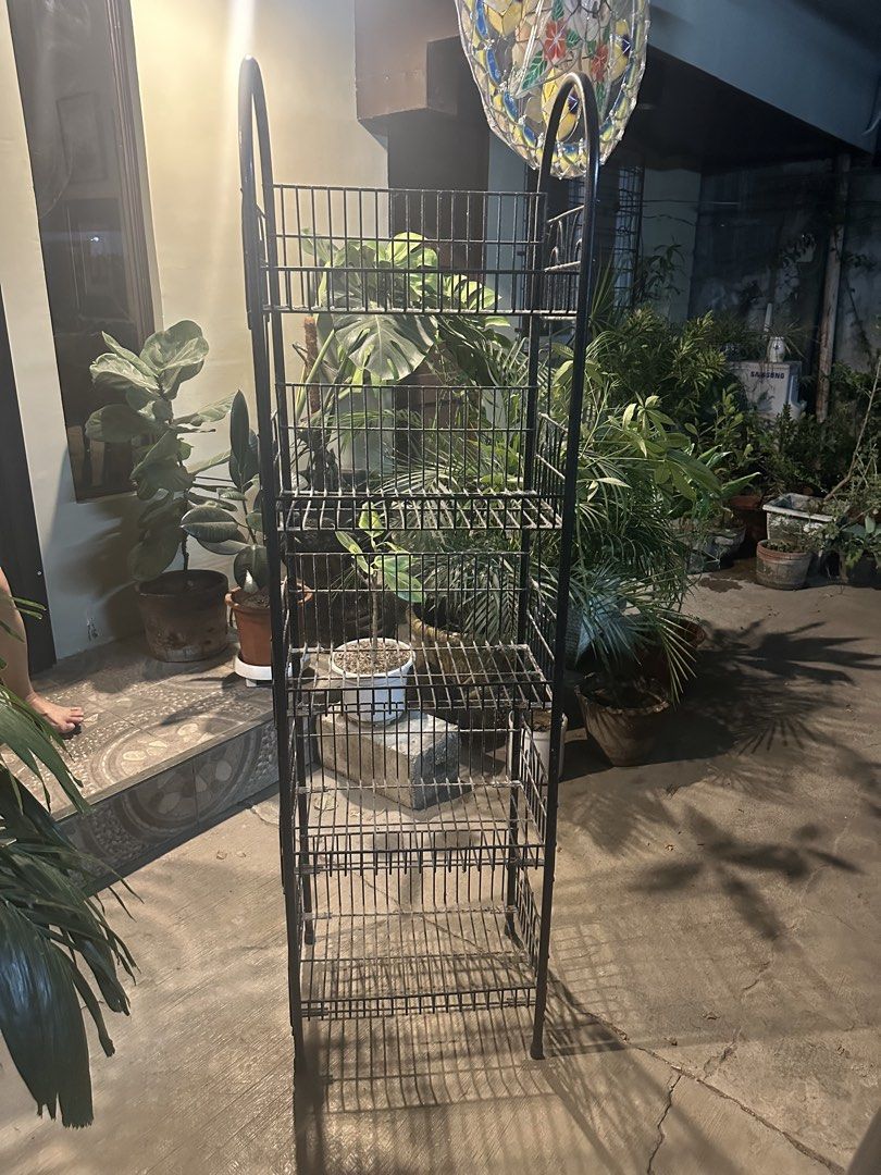 Black Metal Tiered Shelf Rack Stand (Category: Shelves, Cabinets & Racks) located in Cebu City. Submitted by oxywoxy (Listing ID 1461793188, Image 2). Description: - Tall black metal shelf rack - Multiple tiers for storage or display - Perfect for plants or organizing items - Sturdy construction - Ideal for corners or against walls - Ready for a new home.