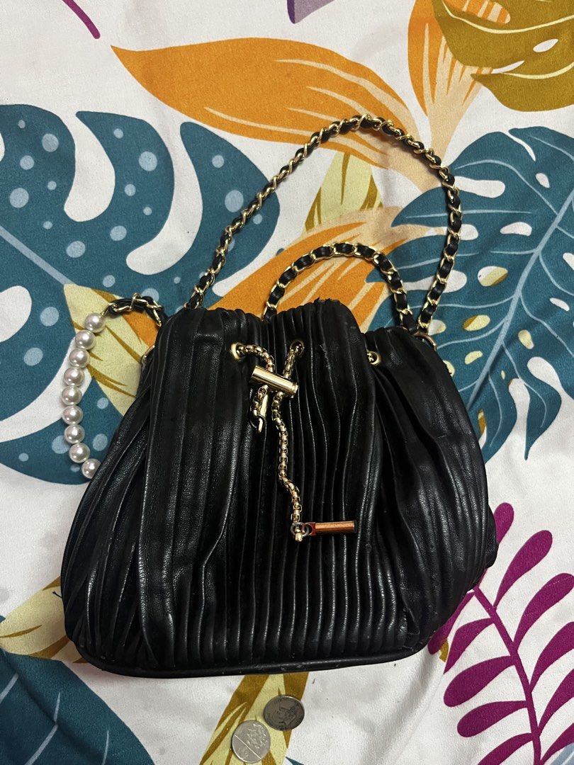 Black Pleated Drawstring Bag with Pearl and Chain Strap (Category: Shoulder Bags) located in Caloocan City. Submitted by evermoonlit (Listing ID 1461566182, Image 2). Description: - Black pleated drawstring bag - Gold chain strap with pearl accents - Gold drawstring detail - Versatile: wear as shoulder bag or crossbody - Ideal for nights out or dressing up outfits - Small and compact size.