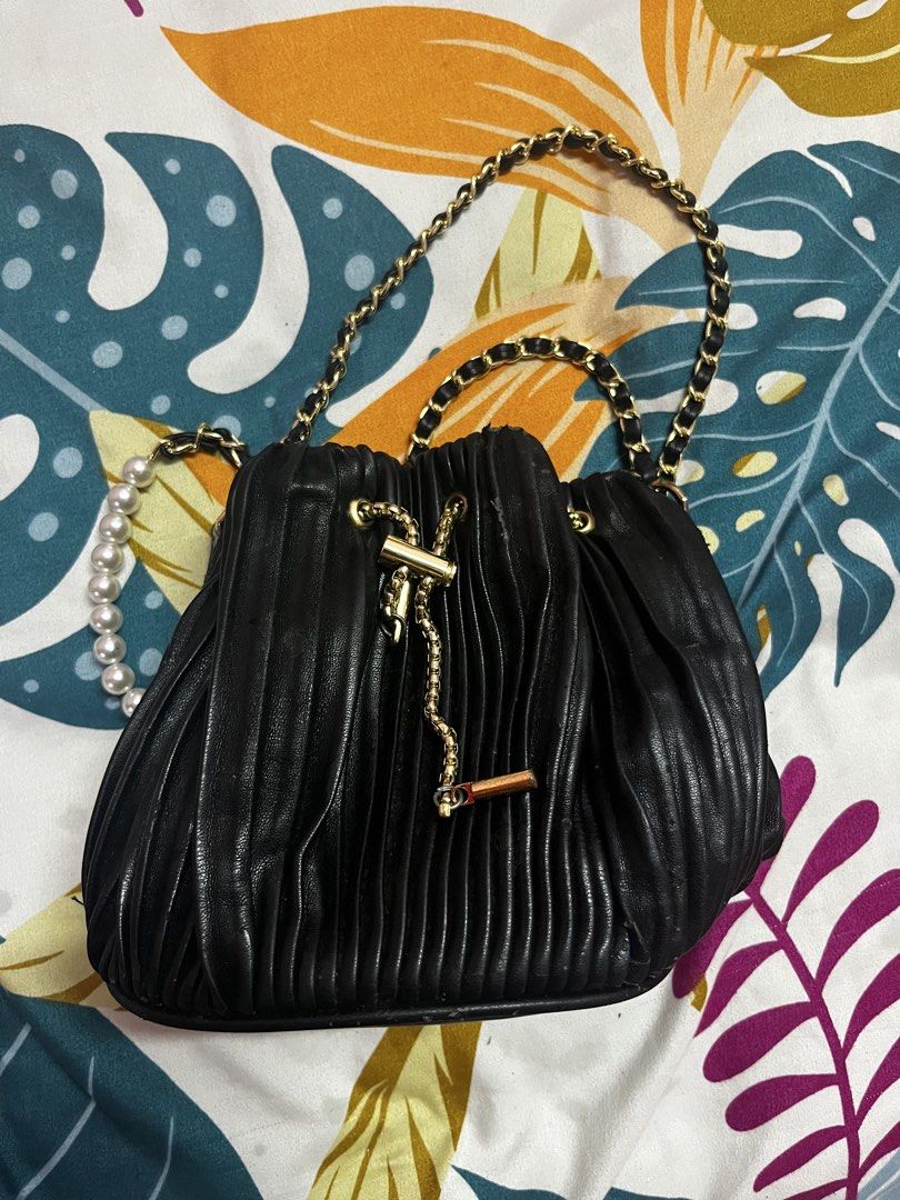 Black Pleated Drawstring Bag with Pearl and Chain Strap (Category: Shoulder Bags) located in Caloocan City. Submitted by evermoonlit (Listing ID 1461566182, Image 1). Description: - Black pleated drawstring bag - Gold chain strap with pearl accents - Gold drawstring detail - Versatile: wear as shoulder bag or crossbody - Ideal for nights out or dressing up outfits - Small and compact size.