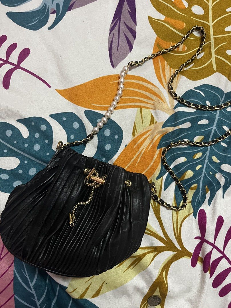 Black Pleated Drawstring Bag with Pearl and Chain Strap (Category: Shoulder Bags) located in Caloocan City. Submitted by evermoonlit (Listing ID 1461566182, Image 3). Description: - Black pleated drawstring bag - Gold chain strap with pearl accents - Gold drawstring detail - Versatile: wear as shoulder bag or crossbody - Ideal for nights out or dressing up outfits - Small and compact size.