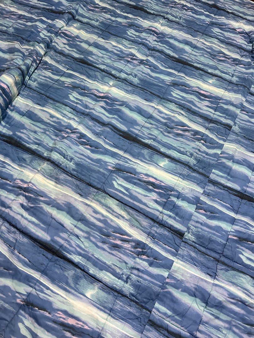 Blue Abstract Pattern Quilt (Category: Bedding & Towels) located in Paranaque City. Submitted by pyassszzzi (Listing ID 1461739415, Image 3). Description: - Blue quilt with a unique abstract wavy pattern. - Design resembles a watercolor painting. - Stitching is clearly visible, adding texture. - Queen size - Versatile use: great for your bed or as a cozy throw..