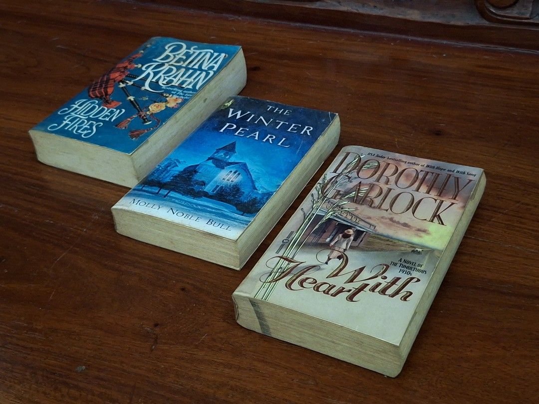 Book Bundle: Romance Adult Books (Category: Storybooks) located in Caloocan City. Submitted by bycara (Listing ID 1461584137, Image 2). Description: Selling three books: 'Hidden Fires' by Bettina Krahn, 'The Winter Pearl' by Molly Noble Bull, and 'With Heart' by Dorothy Garlock. Great reads for your collection. Grab them now! Condition: • Preloved, with signs of wear (yellowed pages, foxing, spine crease, dust marks) • Plastic cover protected 🛵: