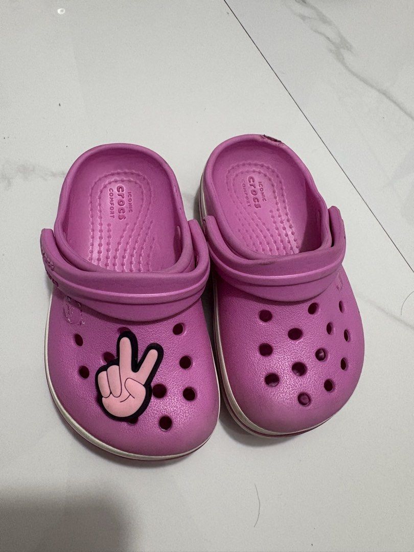 C5 (12cm) - Preloved Crocs (Category: Babies & Kids Fashion) located in Cavite. Submitted by crisalyn___ (Listing ID 1461716147, Image 1). Description: - Adorable pink Crocs for kids - Features a fun peace sign Jibbitz - Easy slip-on style for little feet - Ideal for playtime and casual outings - Soles show some wear but retain good grip.
