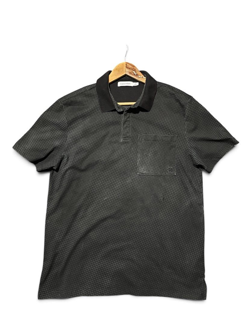 Calvin Klein Men's Black Patterned Polo Shirt (Category: Tshirts & Polo Shirts ) located in Munoz. Submitted by bb_jimbo0 (Listing ID 1461745888, Image 1). Description: - Black Calvin Klein polo shirt - Subtle all-over dot pattern - Chest pocket with small CK logo - Button-up collar - Ideal for casual wear 21 W 28 L.