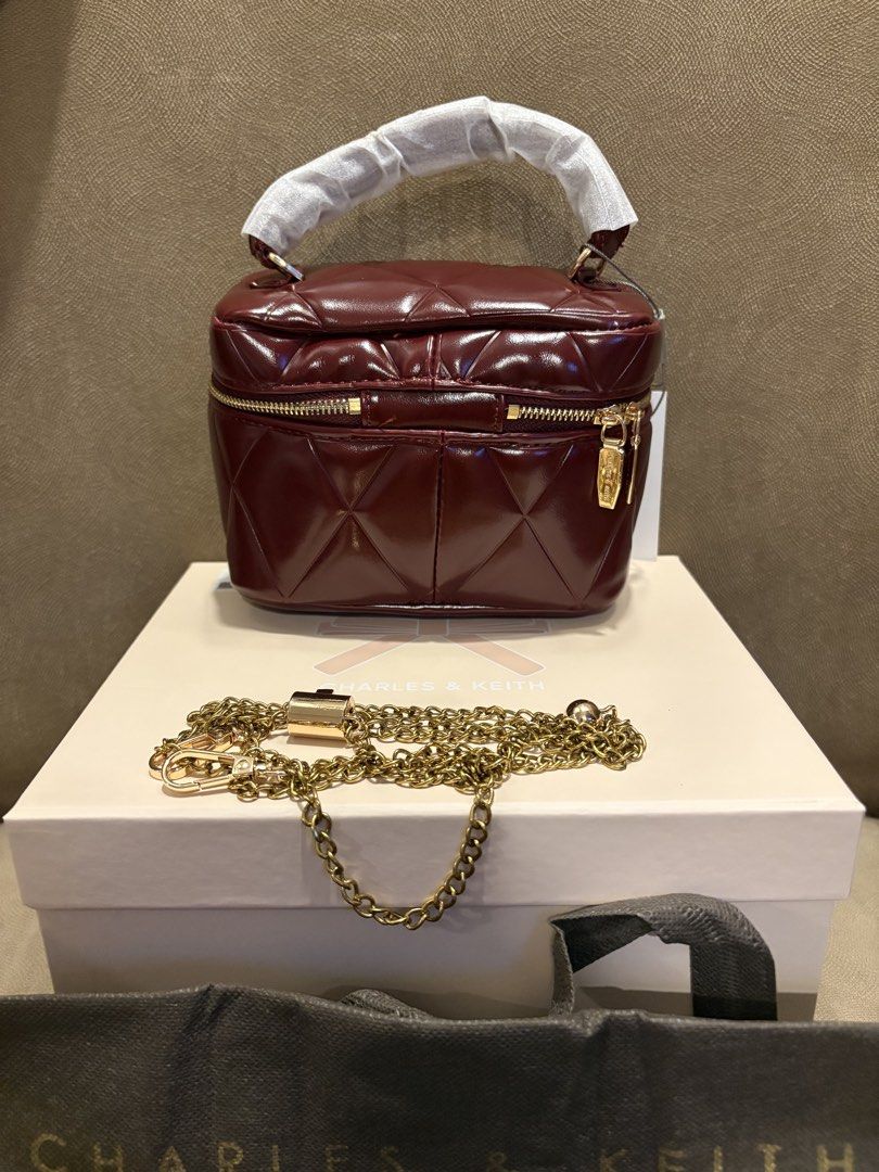 Charles & Keith Burgundy Quilted Vanity Case Bag (Category: Luxury Bags & Wallets) located in Muntinlupa City. Submitted by xiannahailey (Listing ID 1461686770, Image 2). Description: - Burgundy quilted vanity case - Brand: Charles & Keith - Gold chain strap included - Zipper closure - Interior zippered pocket - Original box and dust bag included.