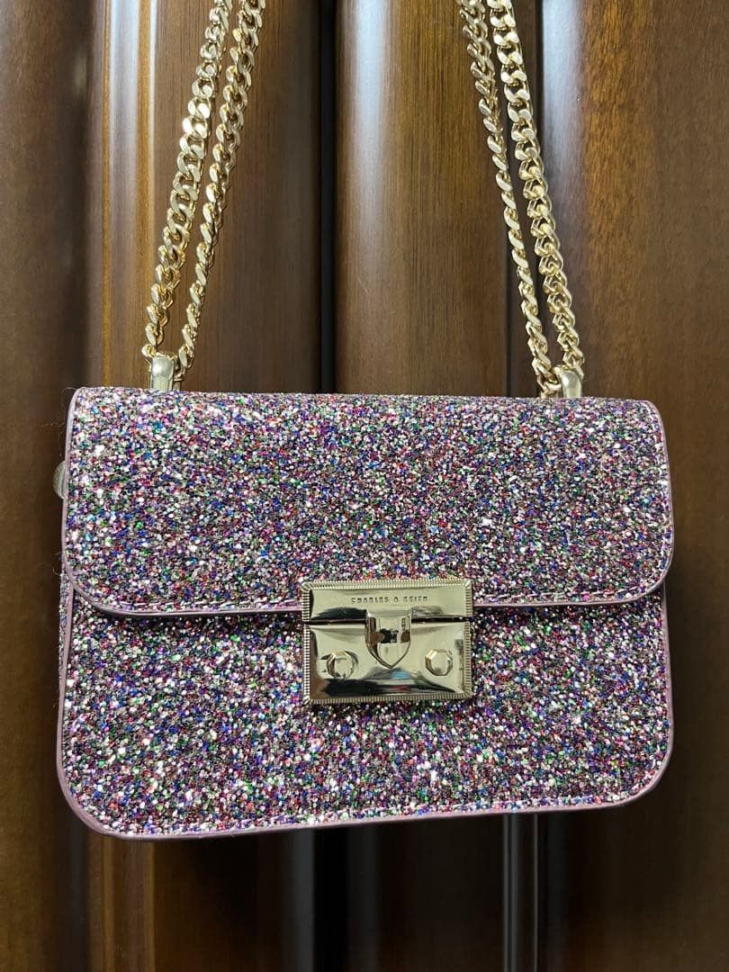 NEGOTIABLE - Charles & Keith Glitter Chain Shoulder Bag (Category: Shoulder Bags) located in Manila. Submitted by prelovedbynatttt_ (Listing ID 1461671899, Image 2). Description: - Sparkly shoulder bag - Gold chain strap - Secure clasp closure - Ideal for nights out or adding glam - Fits essentials (phone, wallet, keys) - Gold hardware details - Bag is clean inside and out Negotiable for sure buyer. Send offer.