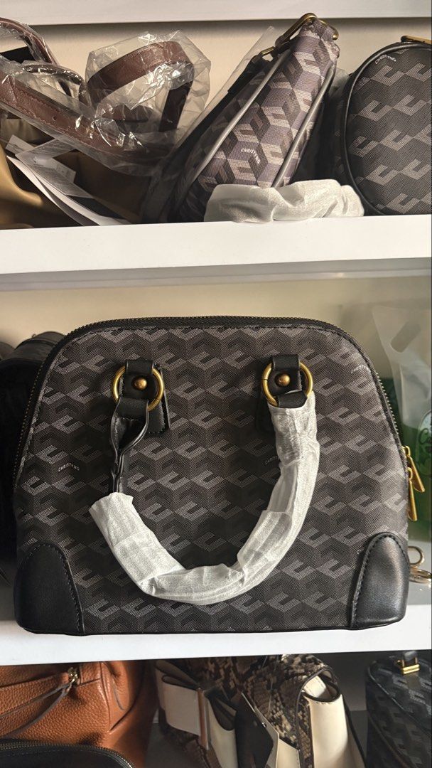 Christy Ng Monogram Dome Satchel Bag (Category: Luxury Bags & Wallets) located in Manila. Submitted by kathrinafu07589 (Listing ID 1461656435, Image 1). Description: - Brand: Christy Ng - Style: Monogram Print Dome Satchel - Color: Black and grey monogram print - Trim: Black leather - Hardware: Gold - Features: Top handles (protective plastic intact), detachable strap - Interior: Spacious, ideal for daily essentials.