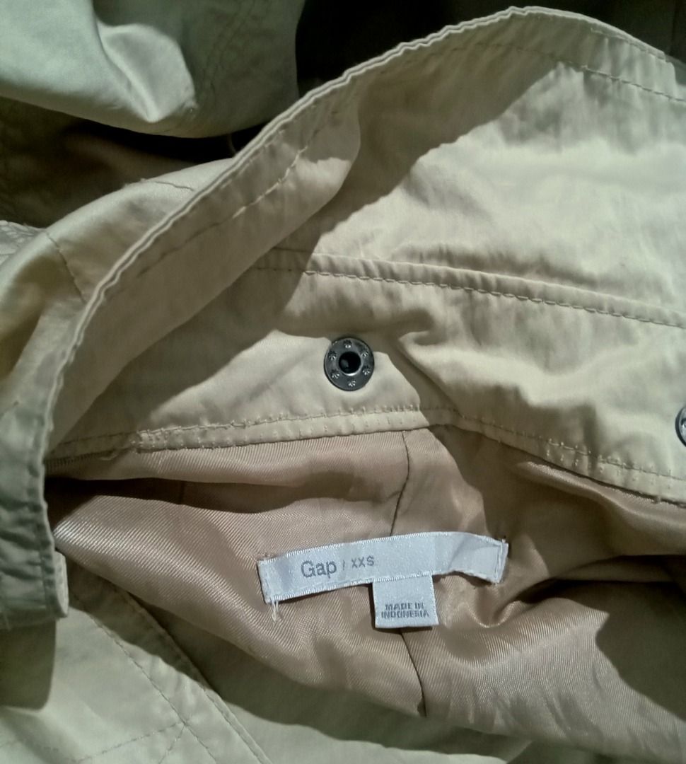 Classic Gap Utility Hooded Trench Coat (Category: Coats, Jackets and Outerwear) located in Baguio. Submitted by pure_vntg53 (Listing ID 1461720731, Image 2). Description: GAP(Authentic Indonesian import) Material: Heavy-duty, water resistant tech shell with a smooth inner lining( 58% polyester, 42% nylon). Features: Removable hood, adjustable cinched drawstring waist, asymmetrical gun flap and unique tied cuff details. Measurements: Pit-pit: 18.5