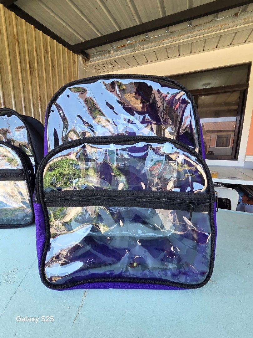Clear Transparent Backpack with Purple Accents (Category: Backpacks) located in Davao. Submitted by gretchenal19856 (Listing ID 1461580302, Image 1). Description: - Clear transparent backpack - Purple fabric accents on edges and straps - Main zippered compartment - Smaller front zippered pocket - Side mesh pockets - Ideal for school or travel.