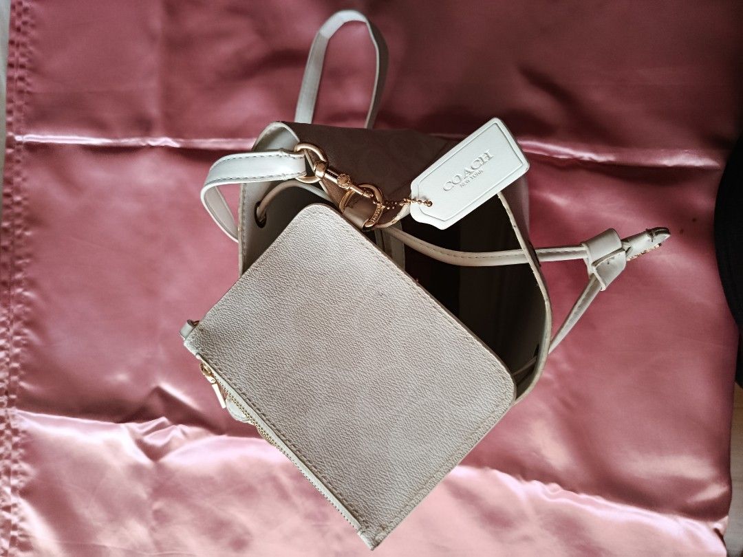 Coach Bucket Bag (Category: Cross-body Bags) located in Pasig City. Submitted by pinkymon1029 (Listing ID 1461736978, Image 3). Description: - Authentic Coach bucket bag - Includes matching coin purse - Color: Off-white - Features signature Coach embossed pattern - Good pre-loved condition (minor marks visible in photos).