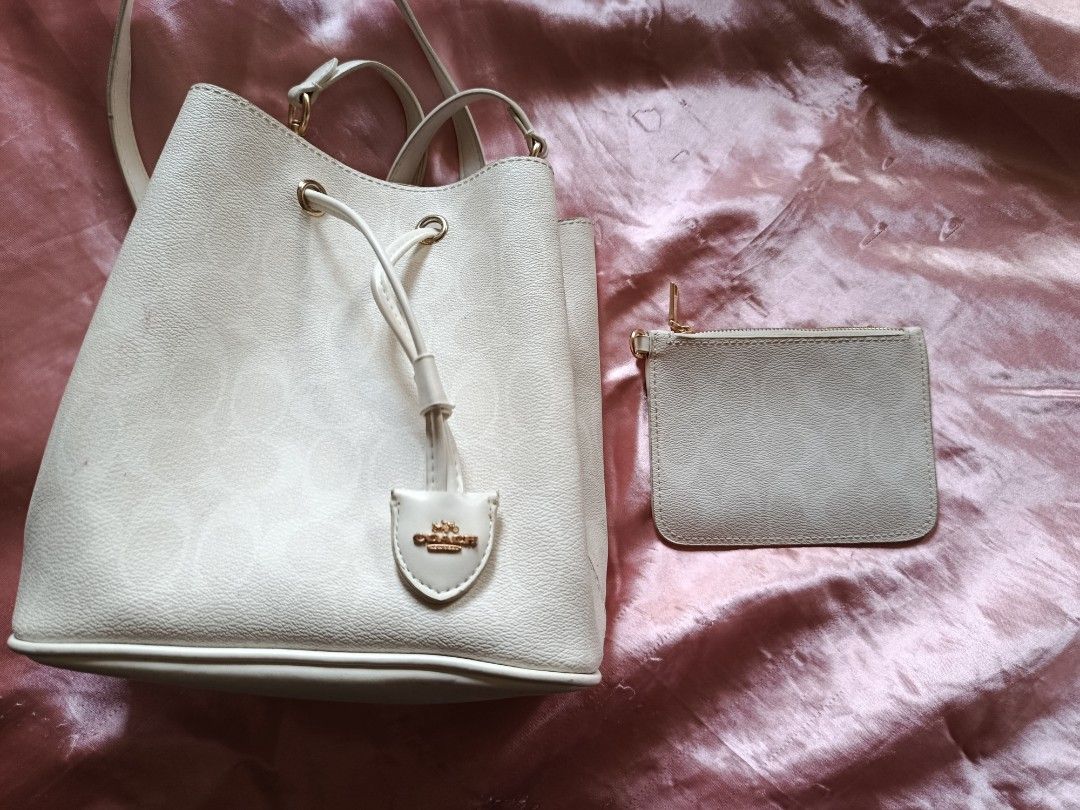 Coach Bucket Bag (Category: Cross-body Bags) located in Pasig City. Submitted by pinkymon1029 (Listing ID 1461736978, Image 1). Description: - Authentic Coach bucket bag - Includes matching coin purse - Color: Off-white - Features signature Coach embossed pattern - Good pre-loved condition (minor marks visible in photos).