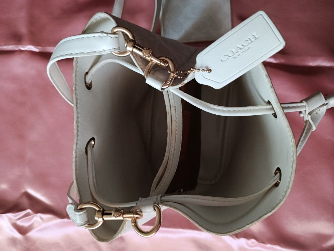 Coach Bucket Bag (Category: Cross-body Bags) located in Pasig City. Submitted by pinkymon1029 (Listing ID 1461736978, Image 2). Description: - Authentic Coach bucket bag - Includes matching coin purse - Color: Off-white - Features signature Coach embossed pattern - Good pre-loved condition (minor marks visible in photos).