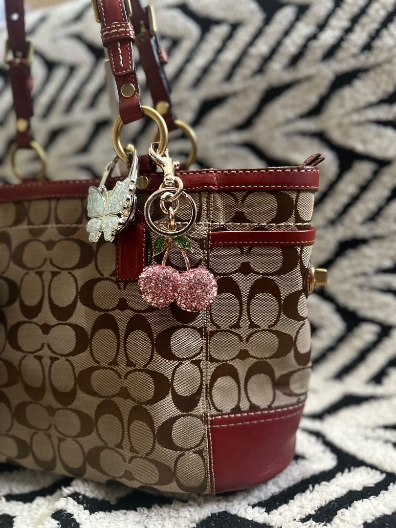 Coach Monogram Canvas & Leather Shoulder Bag (Category: Luxury Bags & Wallets) located in Cebu City. Submitted by isellhere123.543 (Listing ID 1461701329, Image 3). Description: - Classic Coach monogram canvas shoulder bag - Features red leather trim and handles - Interior lined in pink satin with pockets - Charms not included - Great everyday bag.
