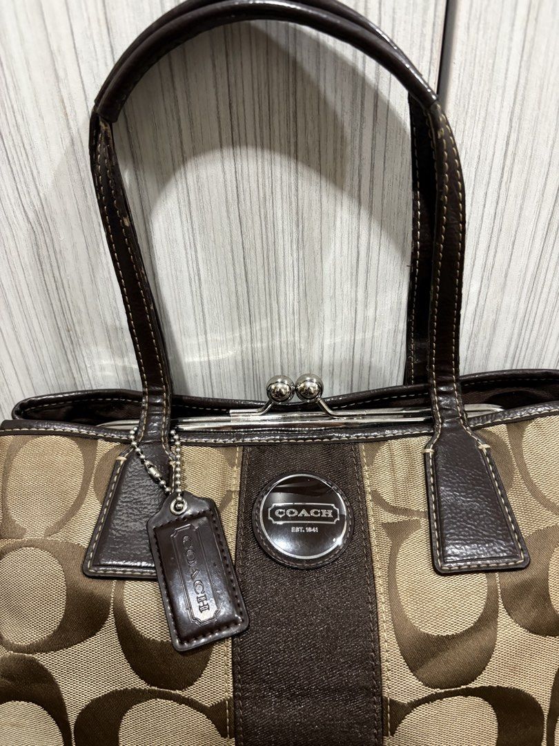 Coach Signature Stripe Framed Carryall (Category: Beach Bags) located in Lingayen. Submitted by jhaneshop (Listing ID 1461735648, Image 2). Description: ☑️ Style No.: F17424 ☑️ Produced: 2011 ☑️ Model/Style: Signature Stripe Framed Carryall ☑️ Creed No.: F1173-F17424 ☑️ Framed center compartment with kisslock closure 📝 Condition: Canvas needs cleaning with some darkened areas. Some parts of the handles show cracking. 💌 Please manage expectation