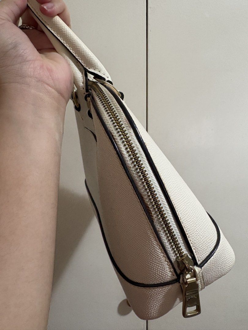 Coach White Leather Dome Satchel Handbag (Category: Luxury Bags & Wallets) located in Caloocan City. Submitted by anneicaro63490 (Listing ID 1461745687, Image 2). Description: - White Coach dome satchel - Textured leather - Gold hardware details - Top handles - Zipper closure - Includes Coach hangtag - Ideal everyday bag, fits essentials Well used but well cared. Signs of usage in the zipper area but not so noticeable. Got this for 10k sa pasabuy