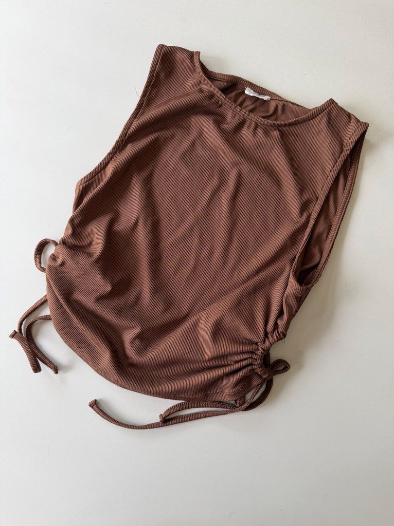Cotton On Ribbed Ruched Tank Top Brown M (Category: Sleeveless) located in Manila. Submitted by thedailythreadclub (Listing ID 1461600872, Image 2). Description: - Brown ribbed tank top from Cotton On - Size: Medium (M) - Features adjustable ruched sides with drawstrings - Sleeveless design - Versatile for casual wear or layering.