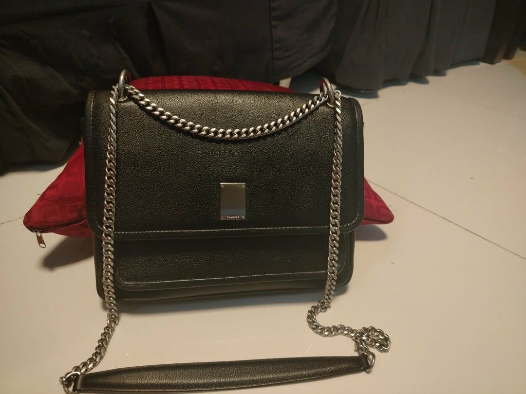 Couronne Black Leather Chain Shoulder Bag (Category: Shoulder Bags) located in Manila. Submitted by wildwind_73f77a (Listing ID 1461585493, Image 2). Description: - Brand: Couronne - Material: Black Leather - Strap: Silver Chain - Closure: Magnetic flap - Interior: Main compartment, zippered pocket - Condition: Clean interior - Best for: Everyday use.