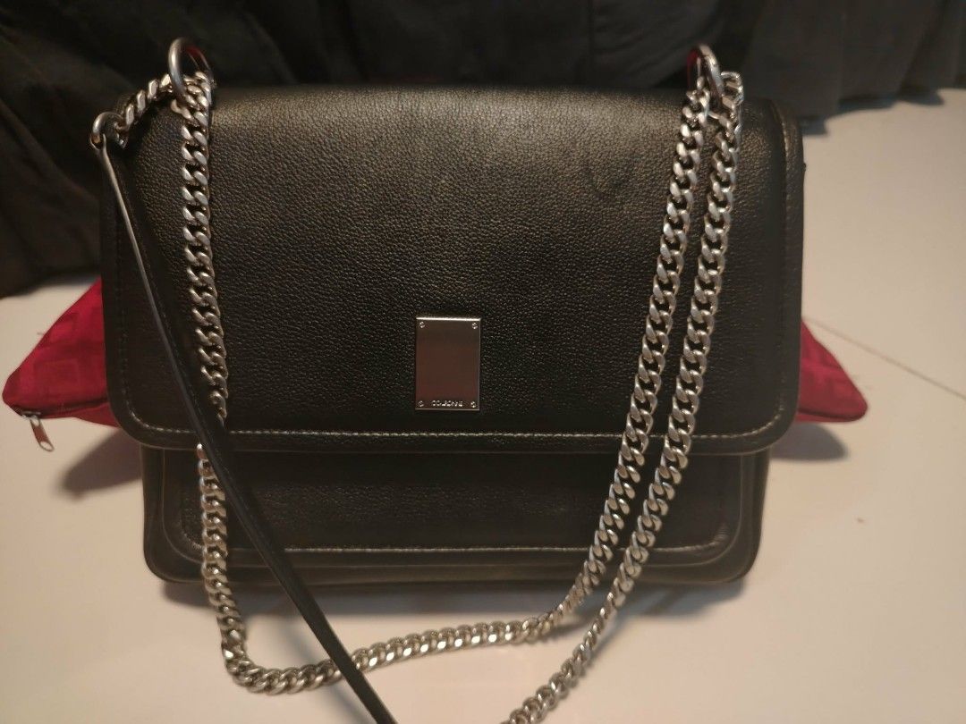 Couronne Black Leather Chain Shoulder Bag (Category: Shoulder Bags) located in Manila. Submitted by wildwind_73f77a (Listing ID 1461585493, Image 1). Description: - Brand: Couronne - Material: Black Leather - Strap: Silver Chain - Closure: Magnetic flap - Interior: Main compartment, zippered pocket - Condition: Clean interior - Best for: Everyday use.