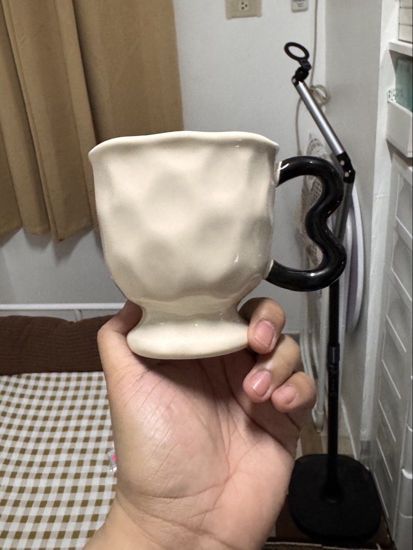 Ceramic Cream Mug with Black Heart Handle (Category: Coffee & Tea Tableware) located in Calamba. Submitted by keemi_ (Listing ID 1461737006, Image 2). Description: - ₱200 - Cream-colored mug - Ceramic - Unique black heart-shaped handle - Ideal for coffee or tea - Standard drink size.