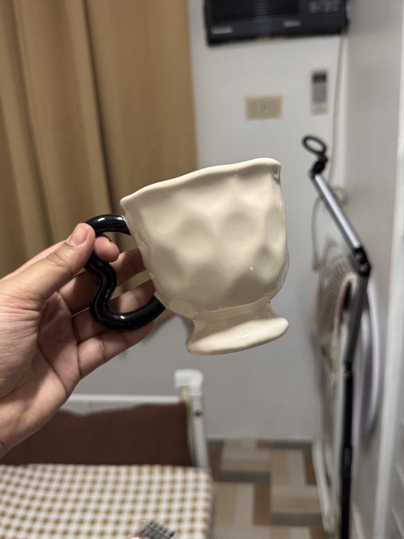 Ceramic Cream Mug with Black Heart Handle (Category: Coffee & Tea Tableware) located in Calamba. Submitted by keemi_ (Listing ID 1461737006, Image 1). Description: - ₱200 - Cream-colored mug - Ceramic - Unique black heart-shaped handle - Ideal for coffee or tea - Standard drink size.