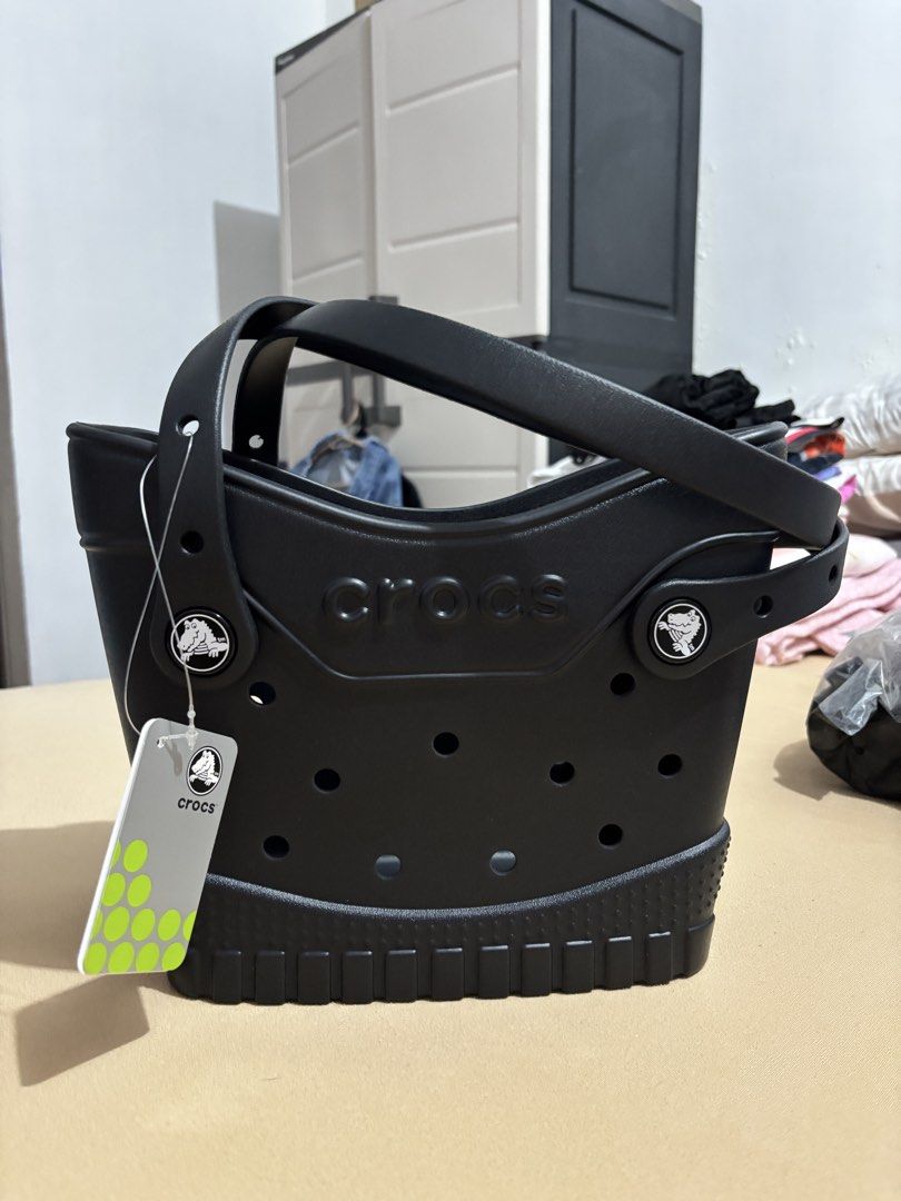 Crocs Black Tote Bag (Category: Tote Bags) located in Lucban. Submitted by quinsdollhouse (Listing ID 1461667744, Image 1). Description: - Brand new black Crocs tote bag - Features classic Crocs holes - Durable sole with rugged tread pattern - Includes original tags - Still sealed in original plastic packaging.