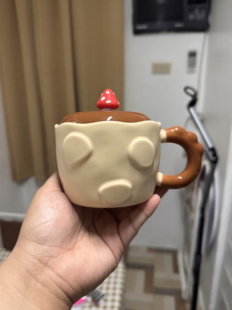 Cute Mushroom Ceramic Mug with Lid (Category: Coffee & Tea Tableware) located in Calamba. Submitted by keemi_ (Listing ID 1461738107, Image 1). Description: - ₱270 - Ceramic mug with lid - Light beige color - Warm brown handle - Ideal for morning coffee or tea. - Makes a great gift.